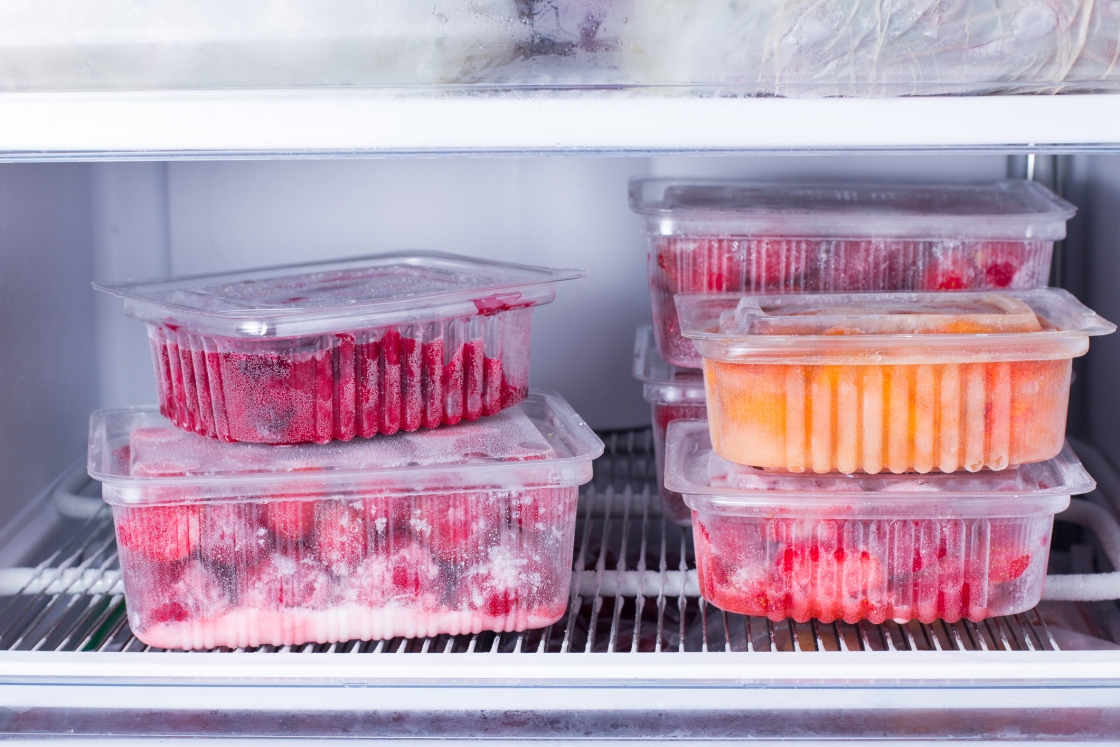 Berries in clear plastic storage containers in a fridge